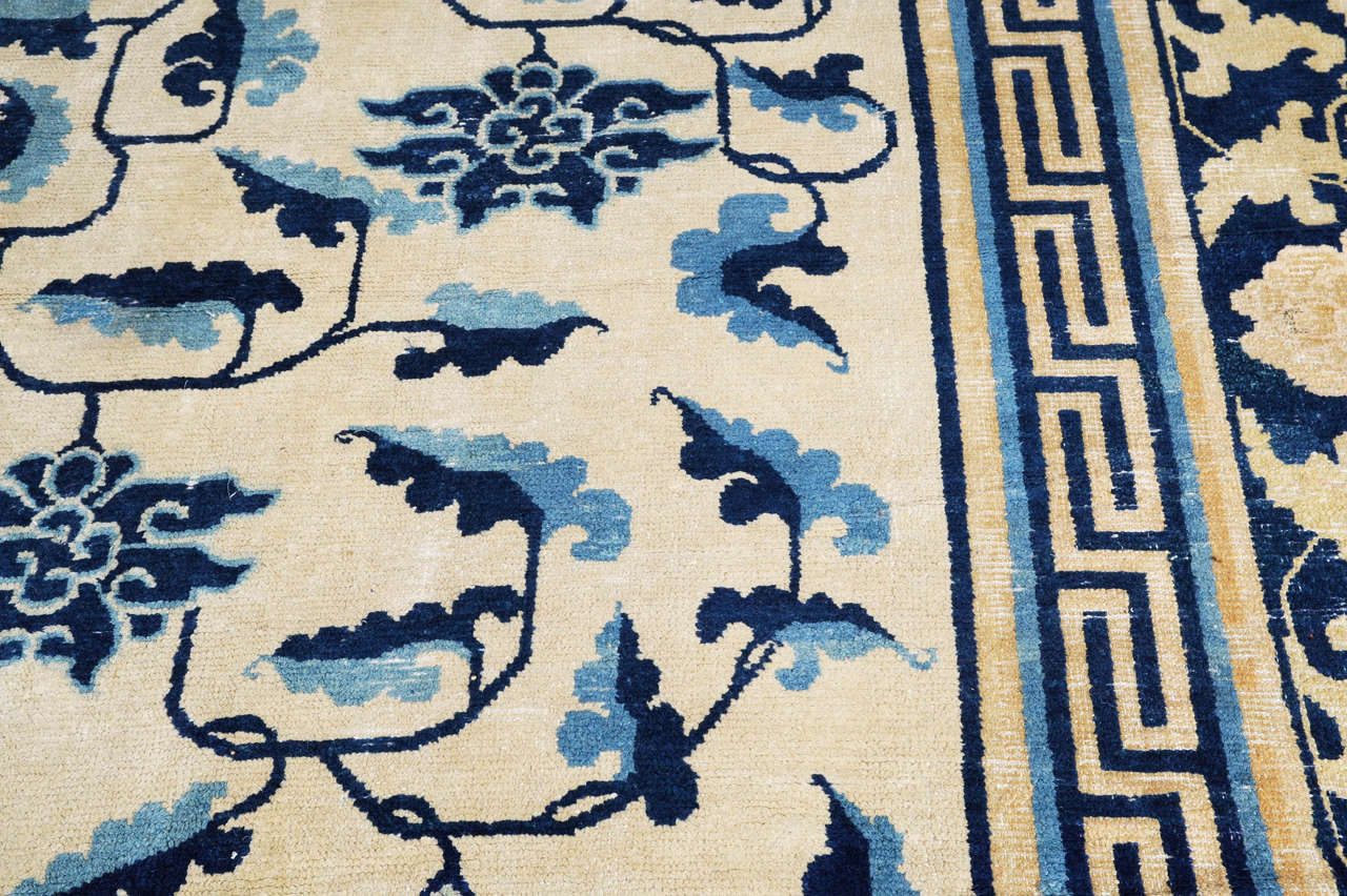 The extremely rare and monumental, ivory background large carpet shown here is decorated by an harmonious pattern of blue and light blue scrolling lotus flowers connected to each other by a Fine tendril and to long leafs with a cloud-like contour.